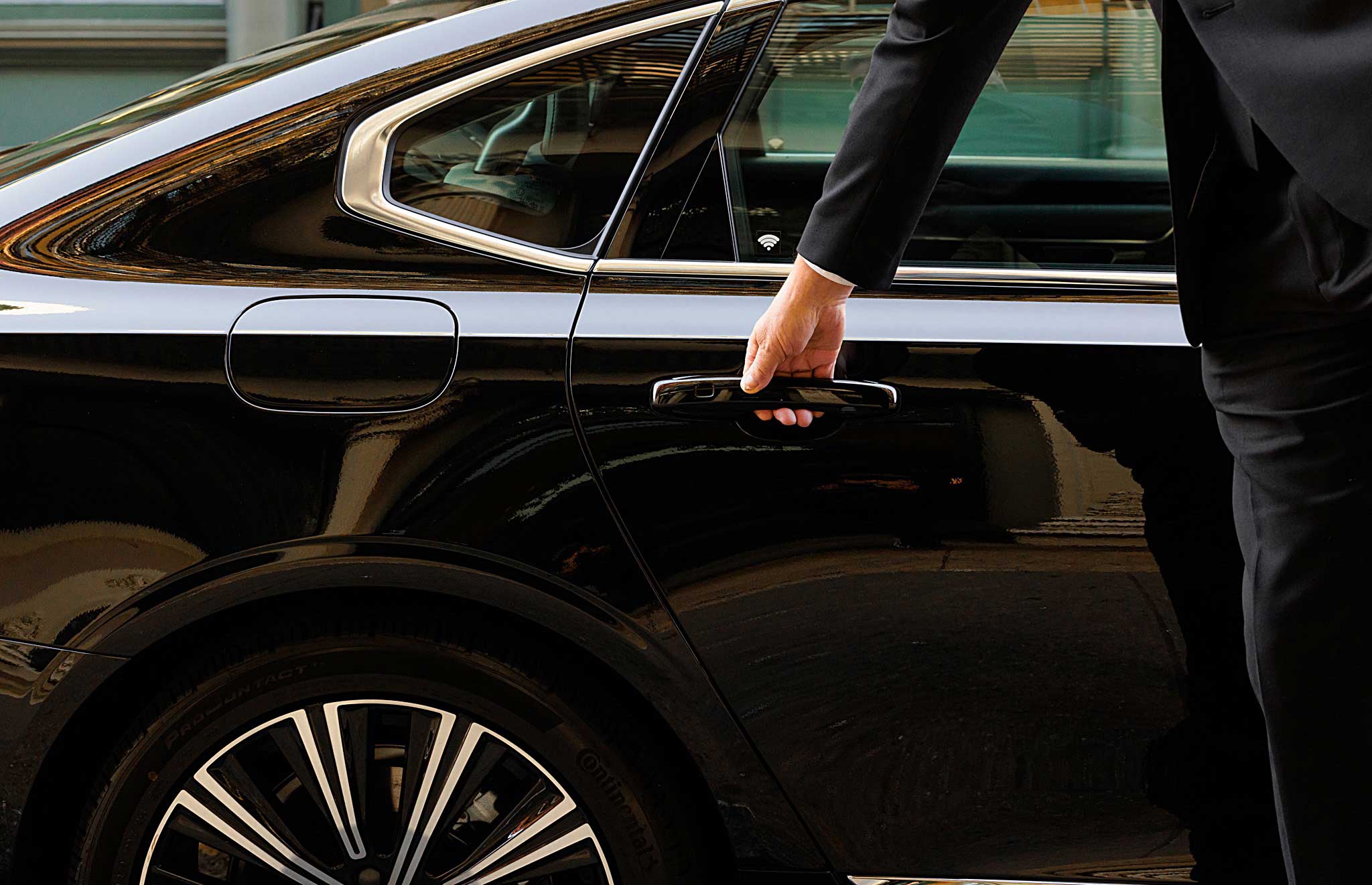 Close-up of chauffeur opening black car door in NYC